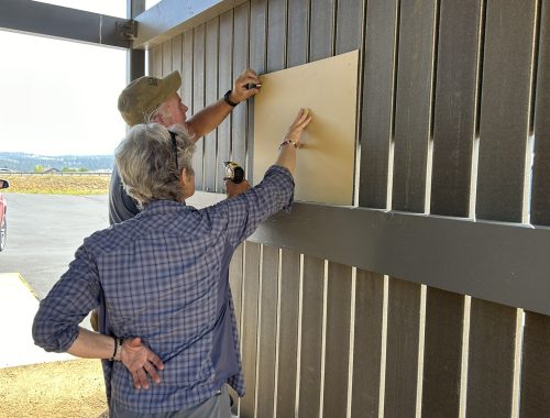TCFSWG board members and volunteers hang the pavillion dedication sign.